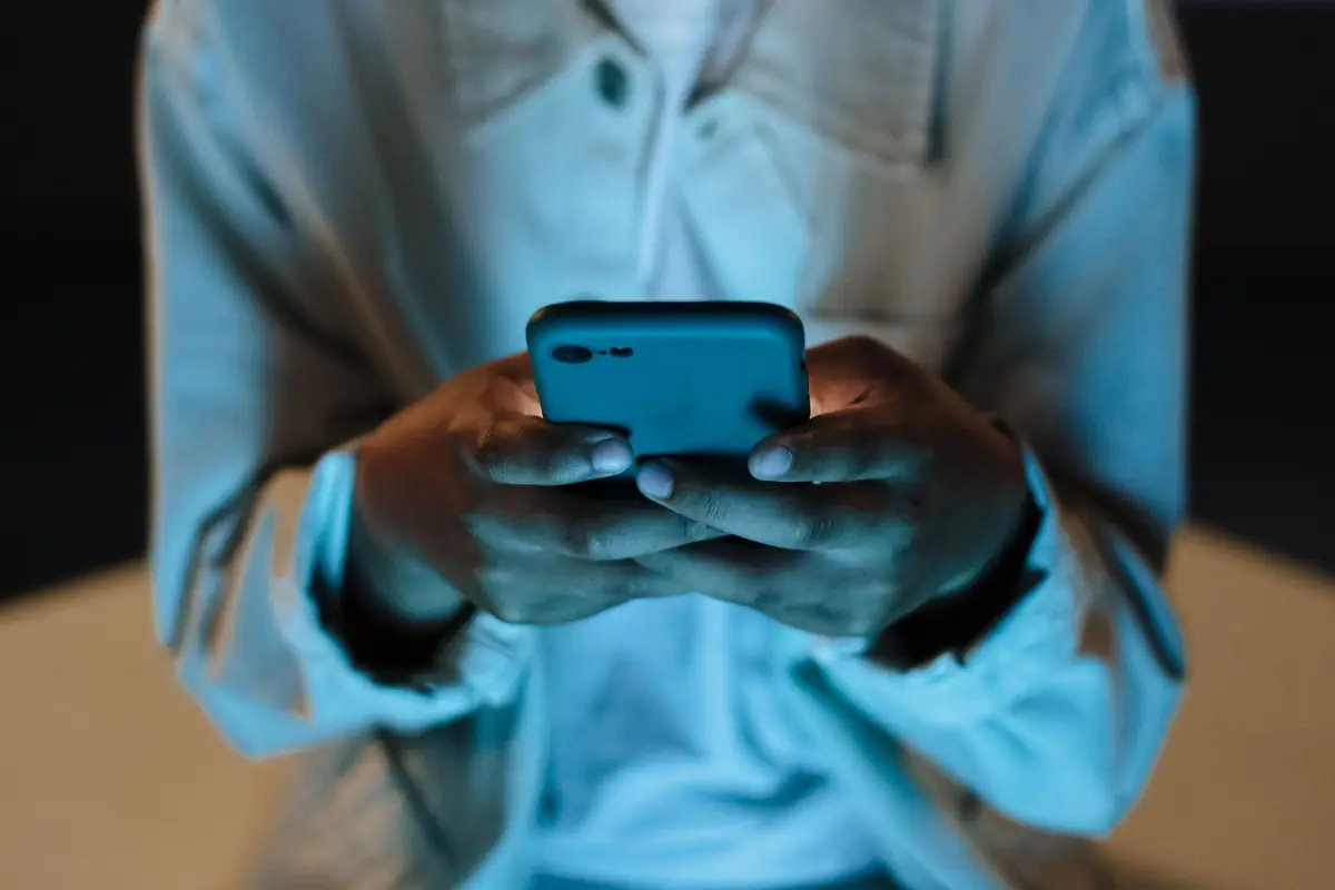 Handen typen een bericht op een telefoon